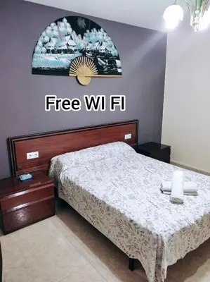 a bedroom with a bed with a free wifi sign on the wall at Habitación CID in Valencia