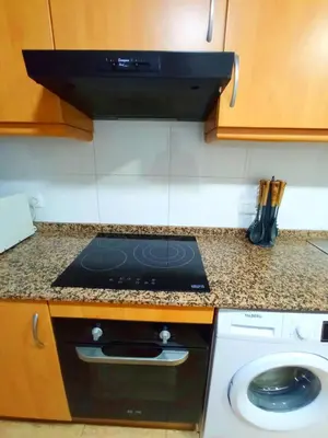 a stove top oven in a kitchen with a counter at Precioso piso in Catarroja