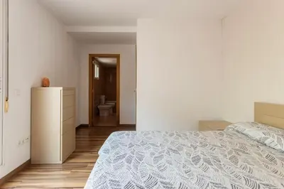 a white bedroom with a bed and a bathroom at Precioso piso in Catarroja