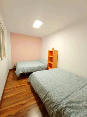 a bedroom with two beds and a shelf in it at Precioso piso in Catarroja
