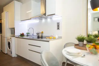 a white kitchen with a table and a sink at SingularStays Xativa III in Valencia