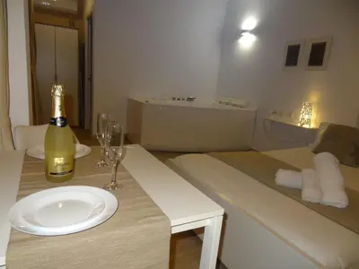 a bottle of wine sitting on a table with a wine glass at Cozy Rooms - BAÑERA HIDROMASAJE in Valencia