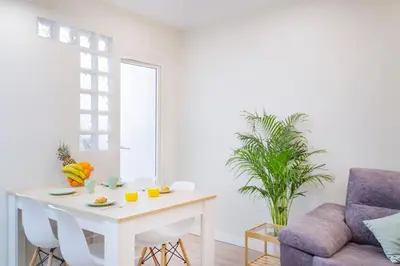 a white living room with a table and a chair at Cabanyal Luxury Malvarrosa Beach in Valencia