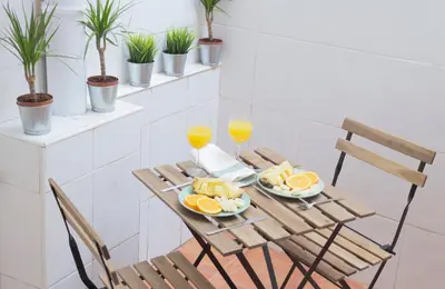 a wooden table with oranges and two glasses of orange juice at Cabanyal Luxury Malvarrosa Beach in Valencia