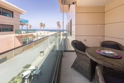 a balcony with a table and a view of the beach at Reinapart Patacona Beach 46 in Valencia