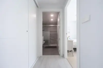 a white bathroom with a walk in shower next to a toilet at Reinapart Patacona Beach 46 in Valencia