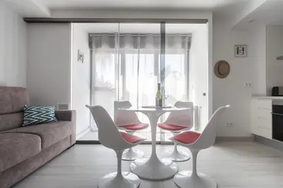 a living room with a table and chairs and a couch at Reinapart Patacona Beach 46 in Valencia