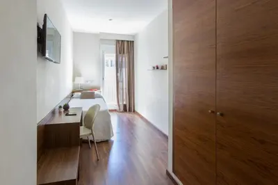 a bedroom with a bed and a desk with a table at Center City Flats in Valencia