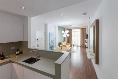 a kitchen with white cabinets and a living room at Center City Flats in Valencia