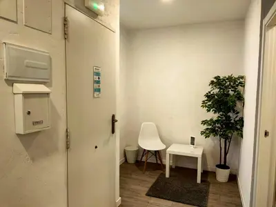a room with a white chair and a table and a plant at Pequeño Alojamiento con Mini Piscina - NO climatizada in Valencia