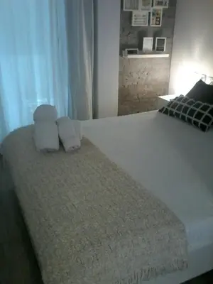 a bedroom with a large white bed with towels on it at Pequeño Alojamiento con Mini Piscina - NO climatizada in Valencia