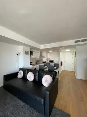a living room with a black couch with pillows at Canet De Berenguer, Playa Apto con 2 habitaciones in Valencia