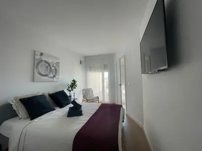 a bedroom with a large bed with a tv on the wall at Canet De Berenguer, Playa Apto con 2 habitaciones in Valencia