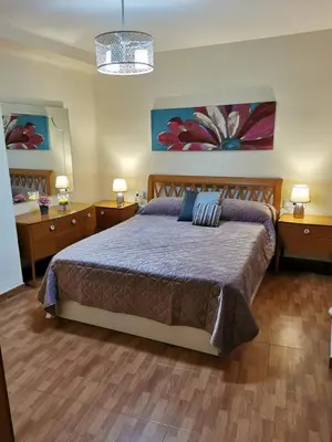 a bedroom with a large bed and two night stands at Precioso y gran apartamento en Cullera in Cullera