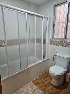 a white bathroom with a toilet and a shower at Precioso y gran apartamento en Cullera in Cullera