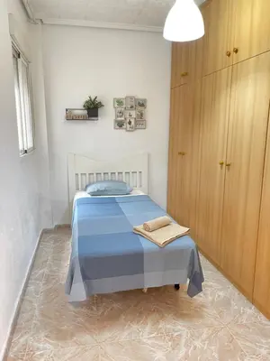 a small bedroom with a blue bed and a cabinet at UIM Mediterraneo PB America Wifi in Puerto de Sagunto
