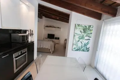 a kitchen with a white table and a microwave at Atico Tapineria in Valencia