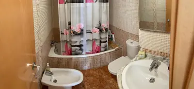 a bathroom with a sink and a toilet with a shower curtain at MAGNIFICO ATICO-DUPLEX FRENTE AL MAR in El Puig