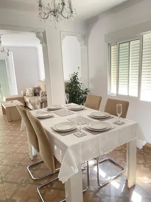 a dining room table with chairs and a white table cloth at Almudafer in Puerto de Sagunto