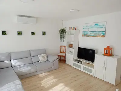 a white living room with a couch and a tv at Apartamento Ciudamar in Puerto de Sagunto
