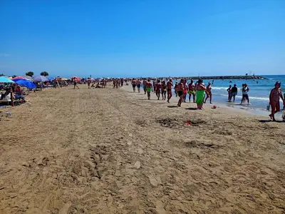 a large group of people walking on a beach at Apartamento Ciudamar in Puerto de Sagunto