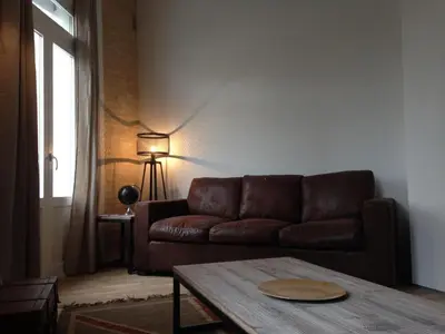 a living room with a brown couch and a table at El 16 Ruzafa in Valencia