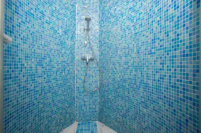 a blue tiled shower in a blue tiled bathroom at SingularStays Valero in Valencia