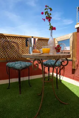 a table and two chairs with a vase of flowers at SingularStays Valero in Valencia