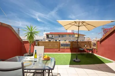 a patio with a table and an umbrella on a roof at SingularStays Valero in Valencia