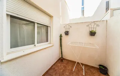 a balcony with a window and a table with potted plants at 2 Bedroom Pet Friendly Home In Sagunto in Sagunto
