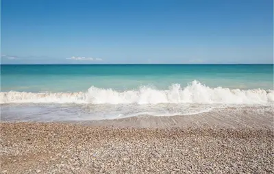 a beach with waves crashing on the shore at 2 Bedroom Pet Friendly Home In Sagunto in Sagunto