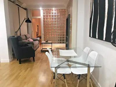 a dining room with a glass table and white chairs at APARTAMENTO JUNTO AYUNTAMIENTO DE VALENCIA in Valencia