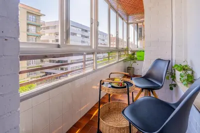 a balcony with two chairs and a table and windows at Apartamento Familiar en Avenida del Puerto in Valencia