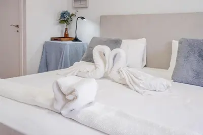 a bed with white blankets and towels on it at Apartamento Familiar en Avenida del Puerto in Valencia
