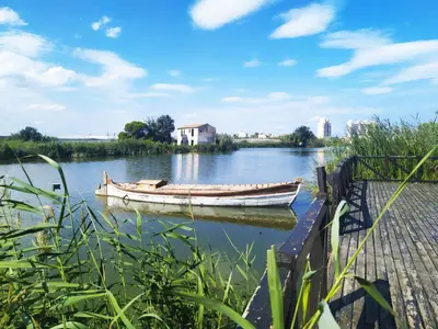 a boat sitting on the water next to a dock at Town center Apartment El Perello Valencia in El Perelló