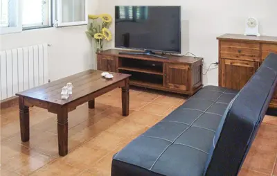 a living room with a couch and a tv at Amazing Home In Riba-Roja De Túria in Riba-Roja De Turia