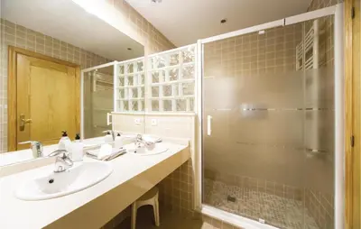 a bathroom with two sinks and a shower at Amazing Home In Riba-Roja De Túria in Riba-Roja De Turia