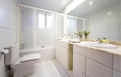 a white bathroom with a sink and a toilet at Amazing Home In Riba-Roja De Túria in Riba-Roja De Turia