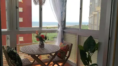 a table and two chairs in a balcony with windows at Espectacular apartment vistas al mar y tranquilidad 10 min desde Valencia in Puebla de Farnals