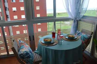 a table with two plates of food in a room with a window at Espectacular apartment vistas al mar y tranquilidad 10 min desde Valencia in Puebla de Farnals