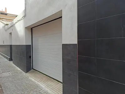 a garage door on the side of a building at Casa cerca de la playa con patio y garaje privado in Puerto de Sagunto