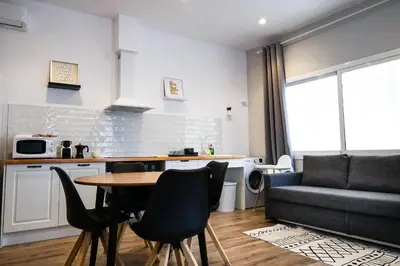 a living room with a table and chairs and a couch at Playa Apartment in Valencia