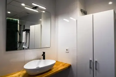 a white bathroom with a sink and a mirror at Playa Apartment in Valencia