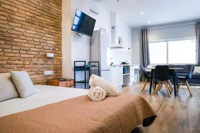 a room with a bed and a kitchen and a dining room at Playa Apartment in Valencia