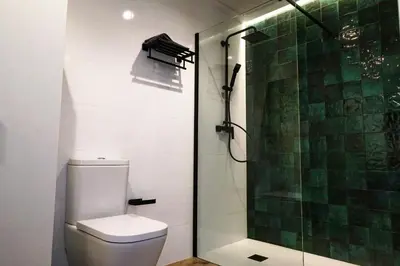 a bathroom with a toilet and a glass shower at Playa Apartment in Valencia