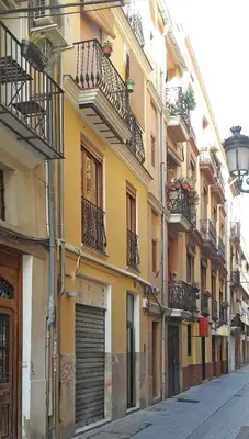 a yellow building with balconies on a city street at Authentic Charming Apartment/Wifi/Air Conditioning in Valencia