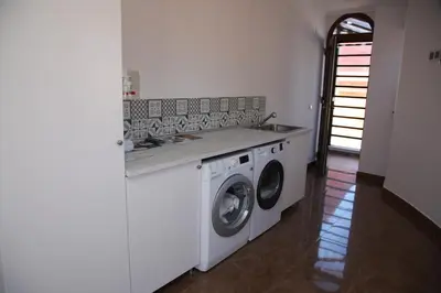 a kitchen with a washing machine and a sink at Casa Genes Chera in Chera
