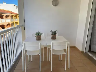 a white table and chairs on a balcony at Precioso apartamento con piscina en Moncofar in Moncófar