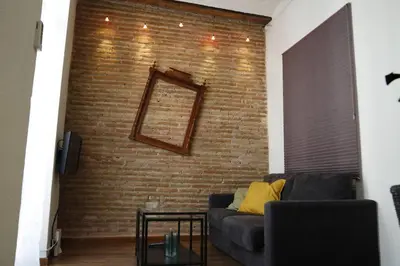 a living room with a couch and a brick wall at Precioso apartamento en el centro histórico in Valencia