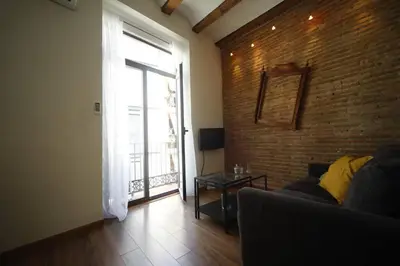 a living room with a couch and a brick wall at Precioso apartamento en el centro histórico in Valencia